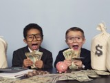 Picture of two kids surrounded by and holding cash