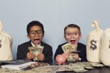 Picture of two kids surrounded by and holding cash