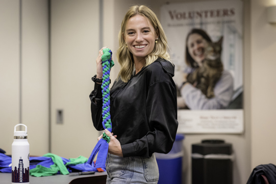 A volunteer shows off a newly-created dog toy.